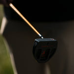 A close-up of a black Gravity golf putter head with a wooden shaft.