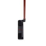 A black golf putter with a red accent on the head and a brown shaft.