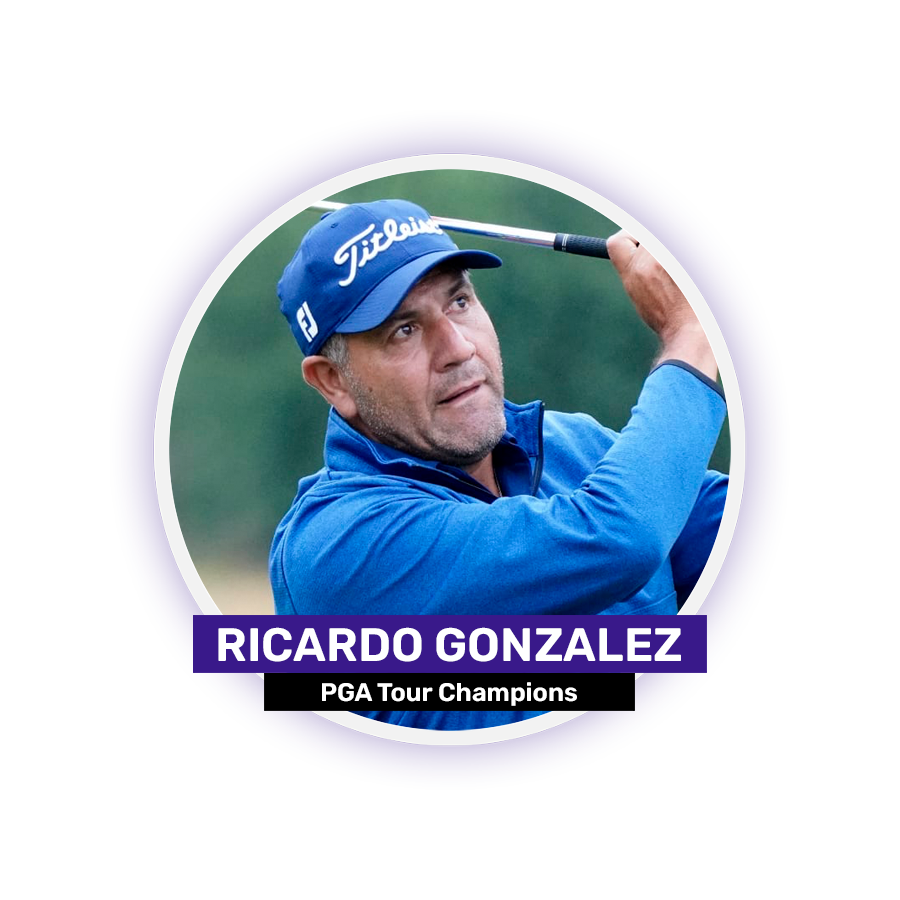 A golfer in a blue jacket and cap swings a golf club.